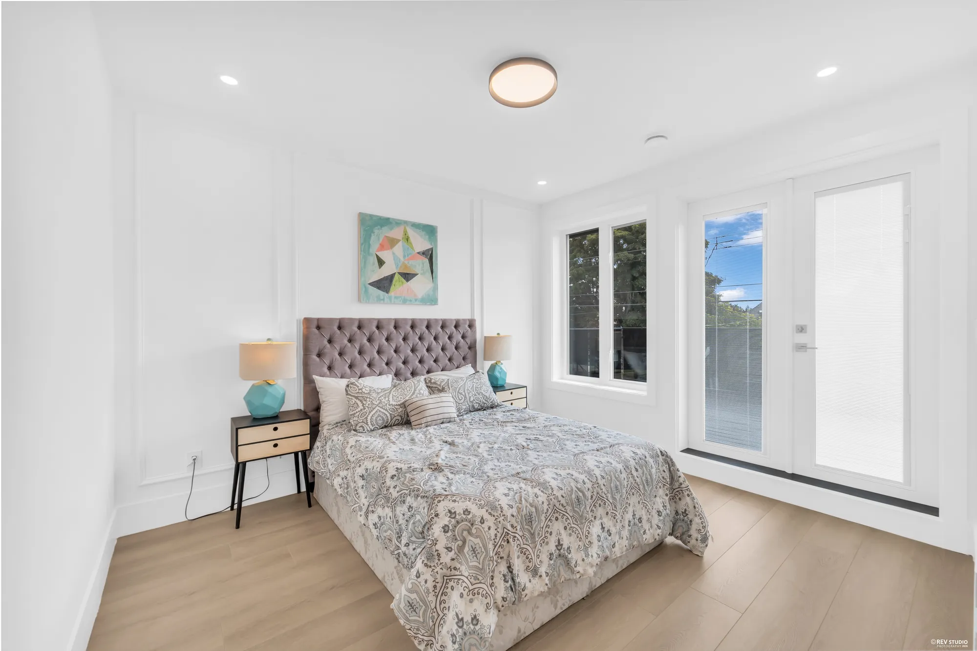 A dressed bedroom with glazed doors out to the balcony