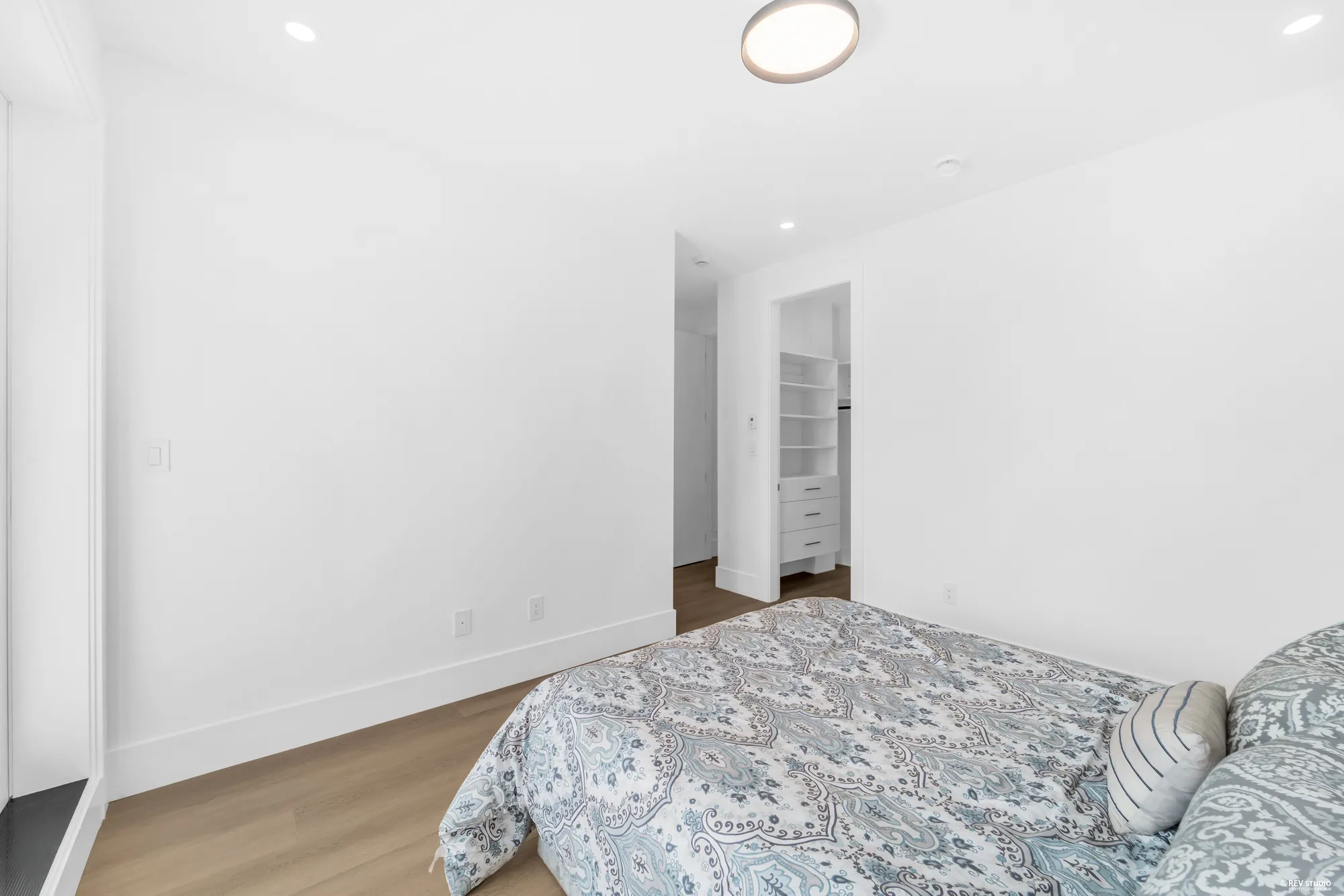 The same bedroom looking the other way, a fitted walk-in closet through the doorway