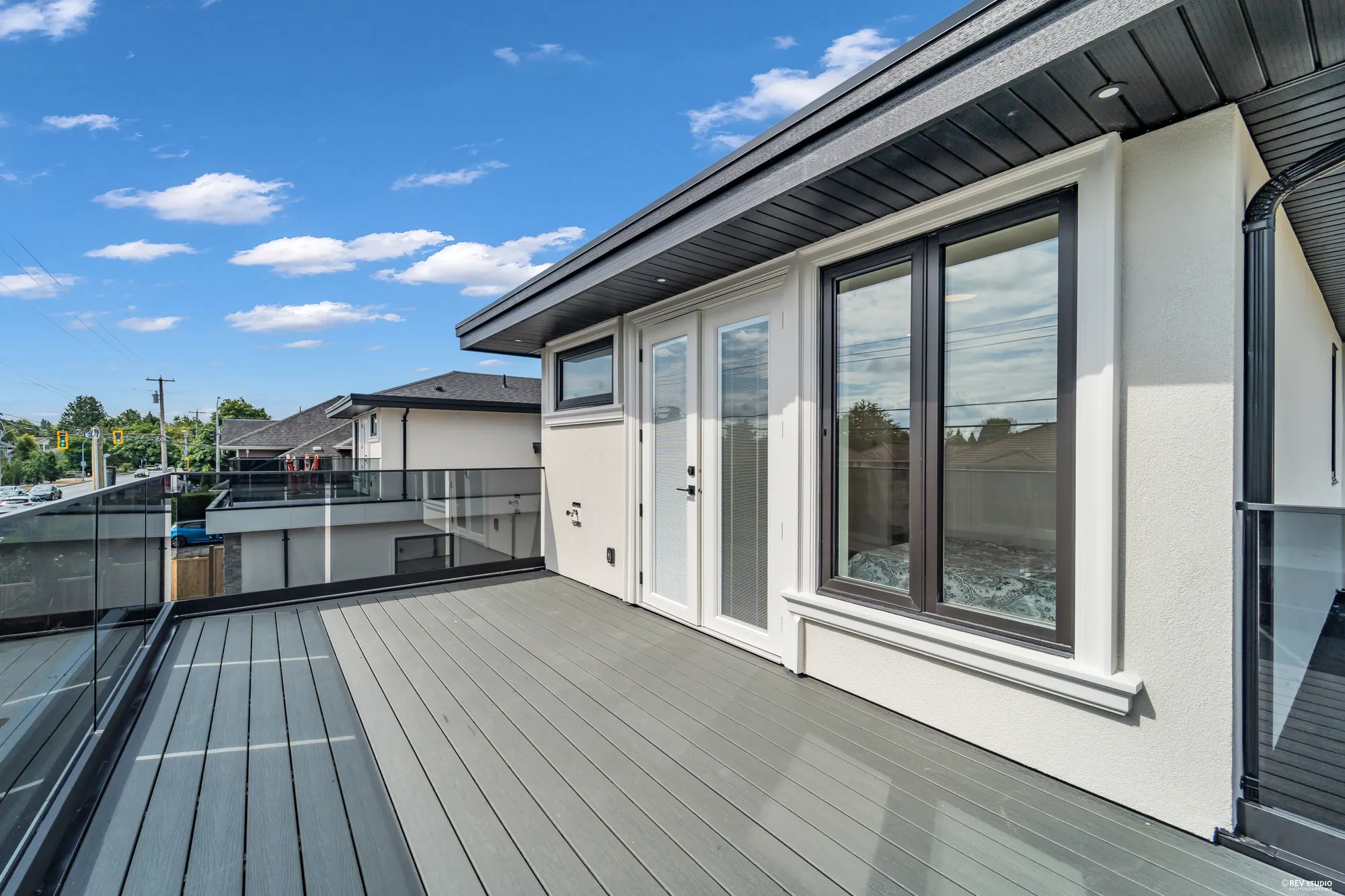 The balcony along the front of the upper floor, composite boards and a glass rail