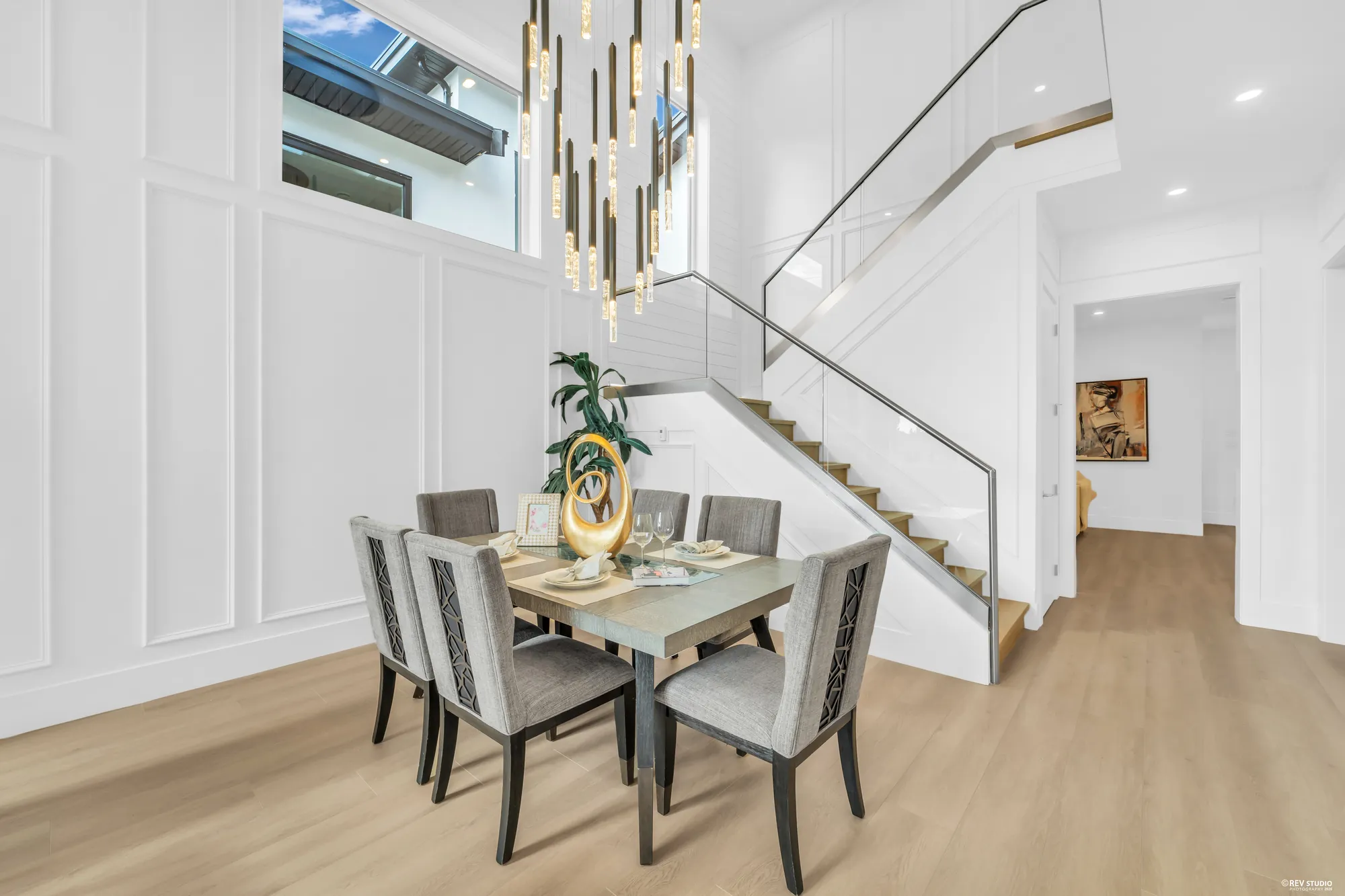 The dining table set for six, the stair rising behind it