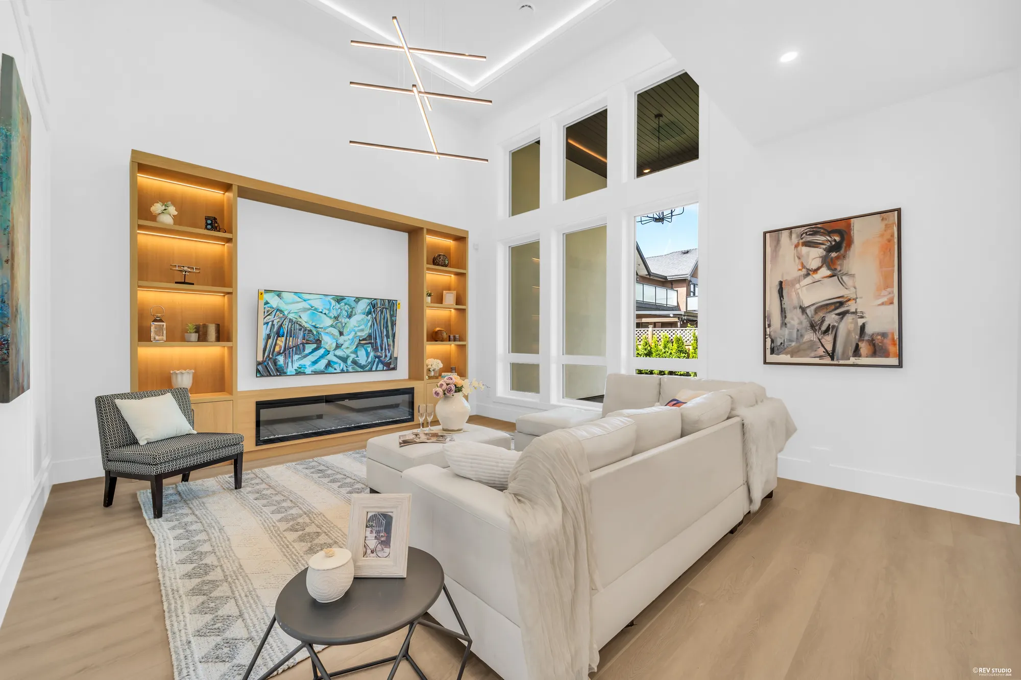 The built-in media wall in oak with lit shelves either side of a fireplace