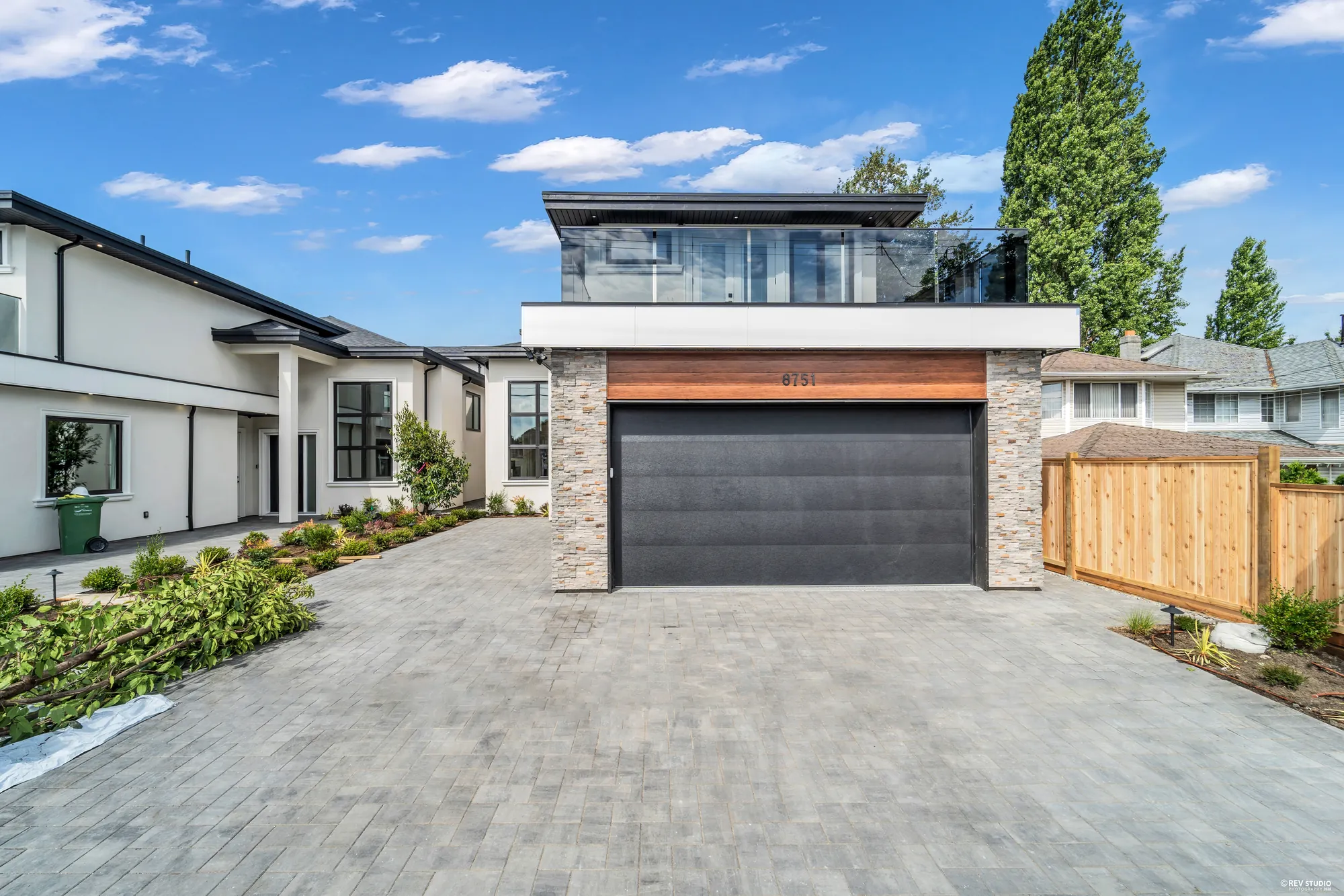 Closer on the garage, the stone piers and the front door recessed to the left