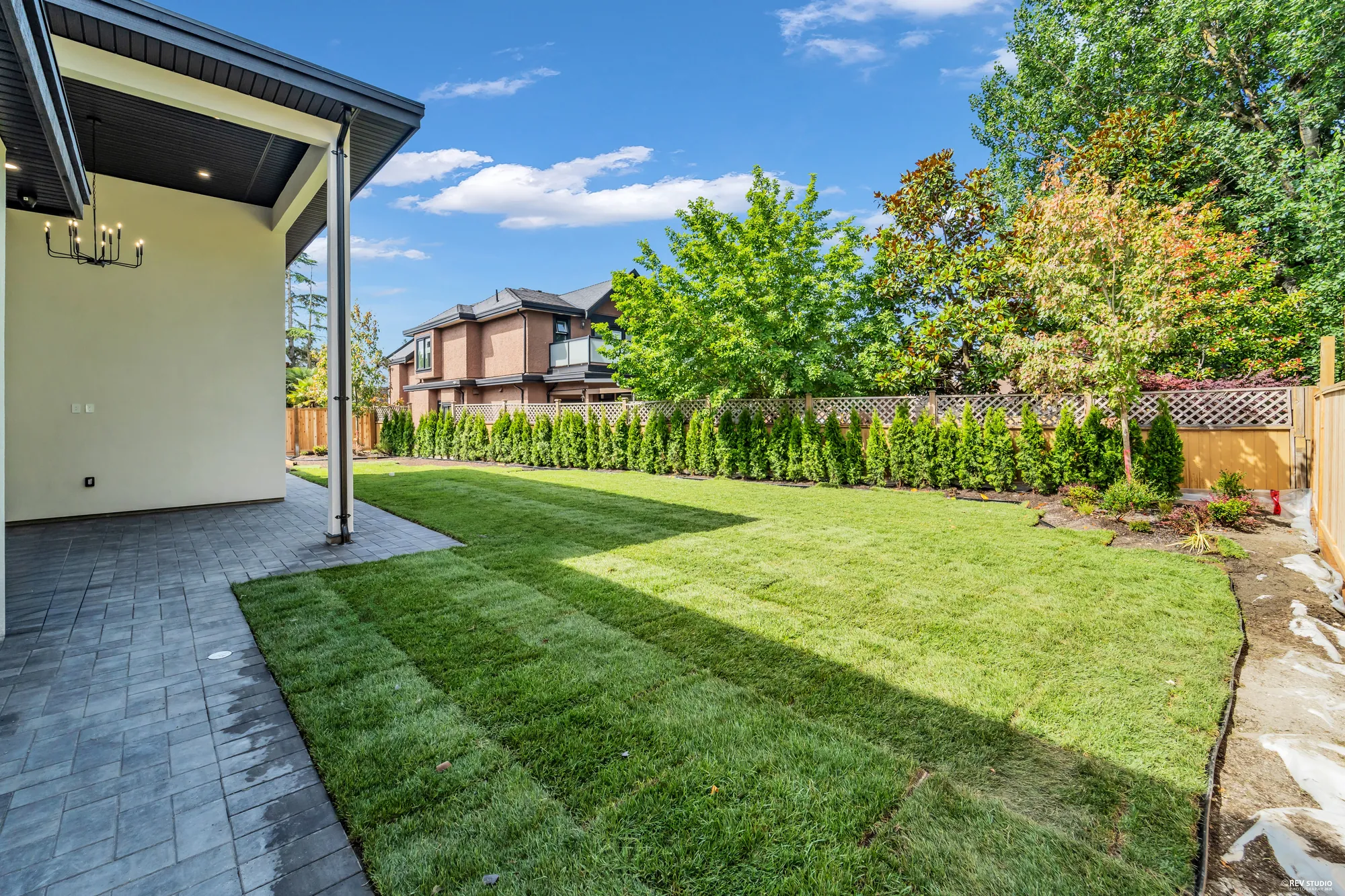 The back garden, turfed and fenced in cedar, hedging along the boundary