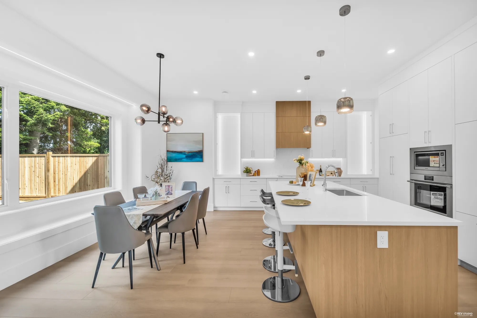 The breakfast nook under a cluster of glass pendants beside the garden window